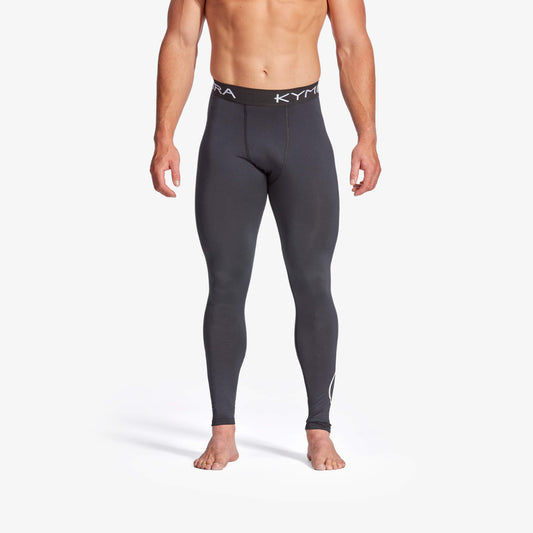 Person wearing gray compression leggings with a white background