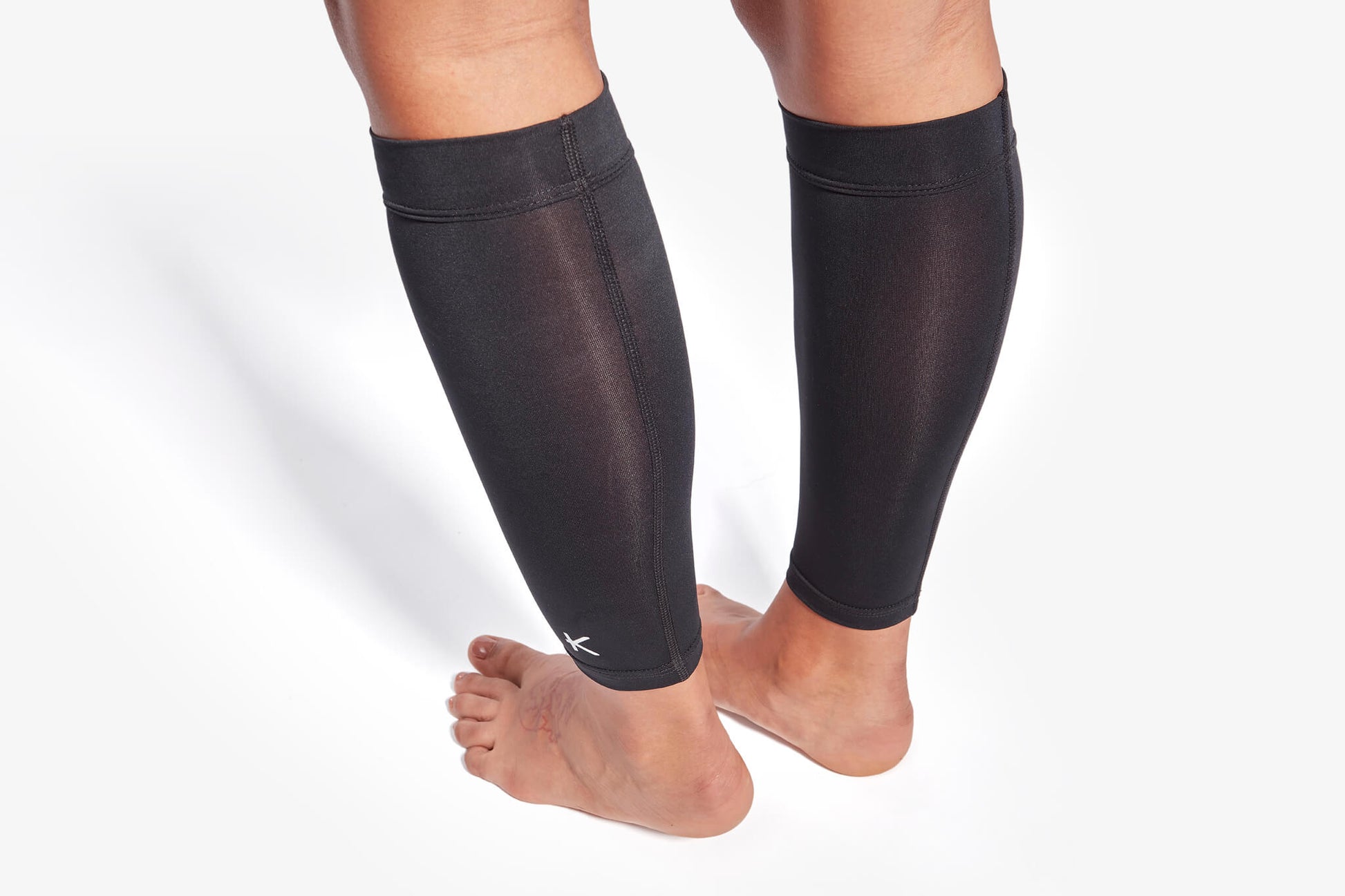 Black compression sleeves on legs against a white background