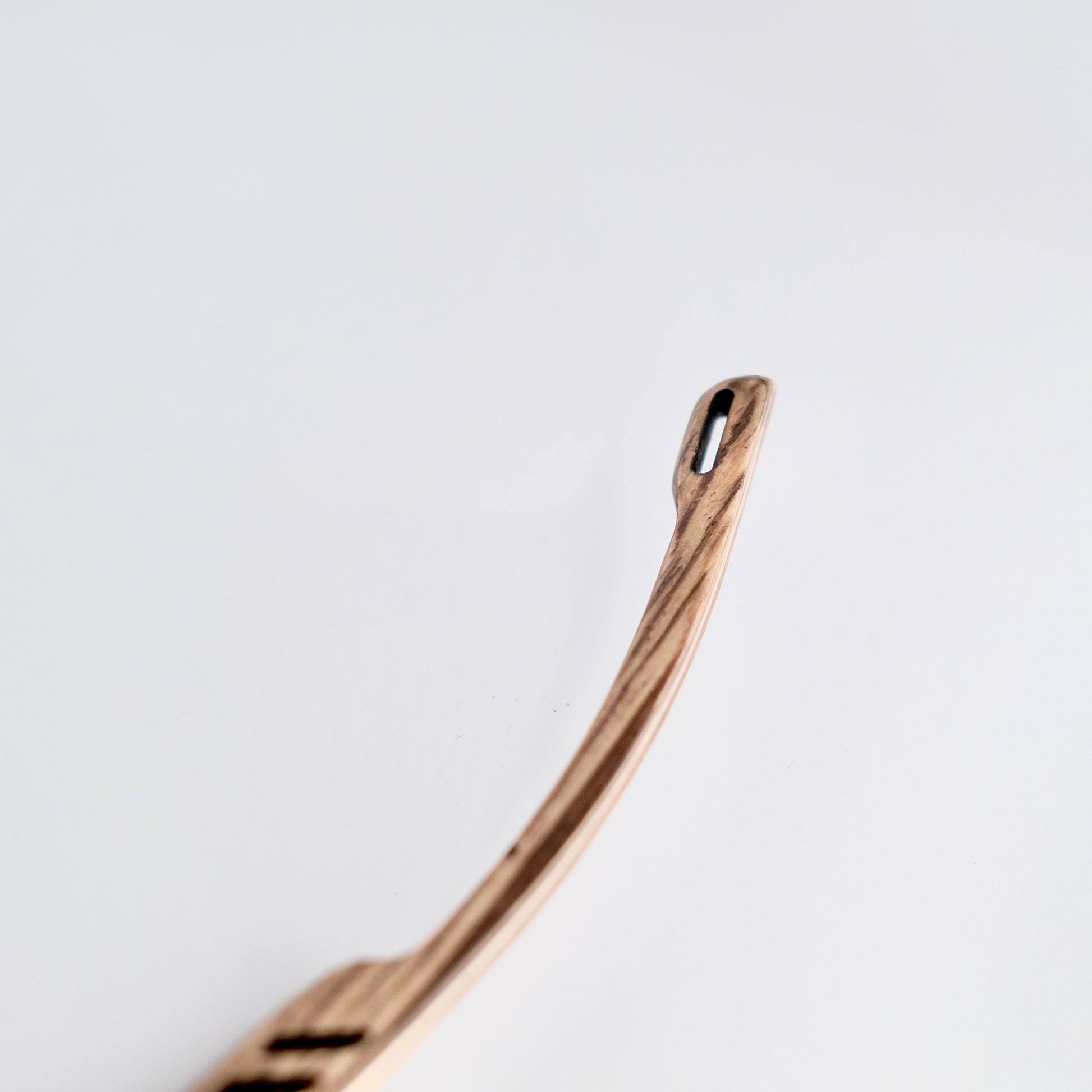 Bronze-colored spoon on a light gray background