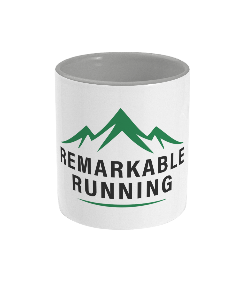 White mug with green mountains and black text on a white background