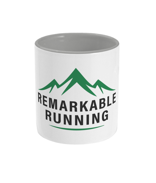 White mug with green mountains and black text on a white background