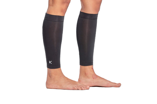Black compression sleeves on legs with a clear background