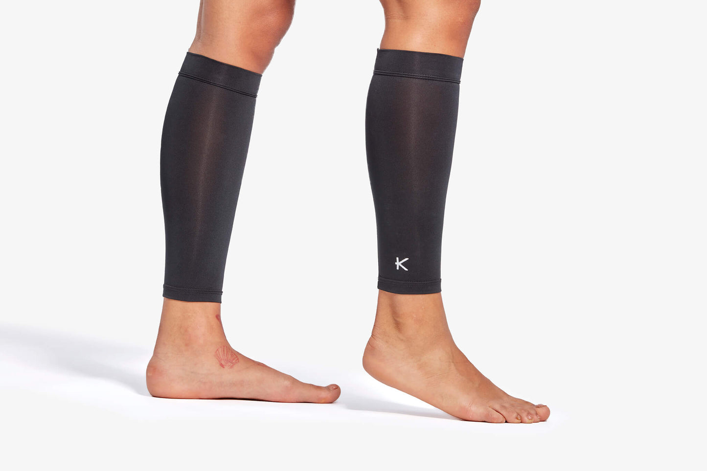 Black compression sleeves on legs with a visible brand logo against a white background