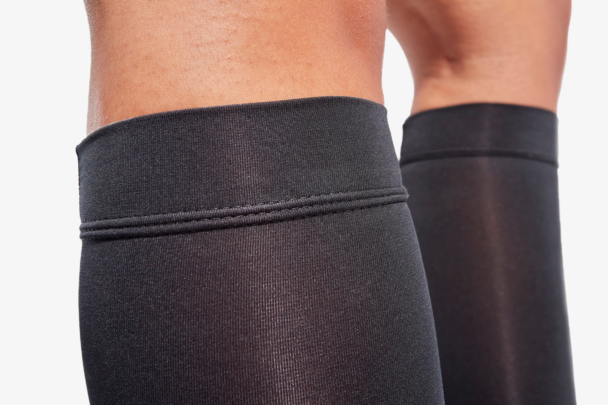Close-up of black compression stockings on a neutral background